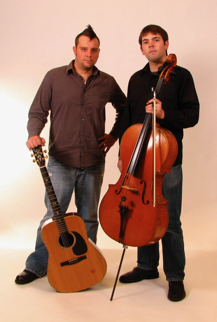 Josh Hisle and Michael Ronstadt hold instruments.