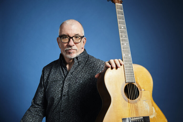 James Keelaghan portrait. He is holding guitar in front of him.