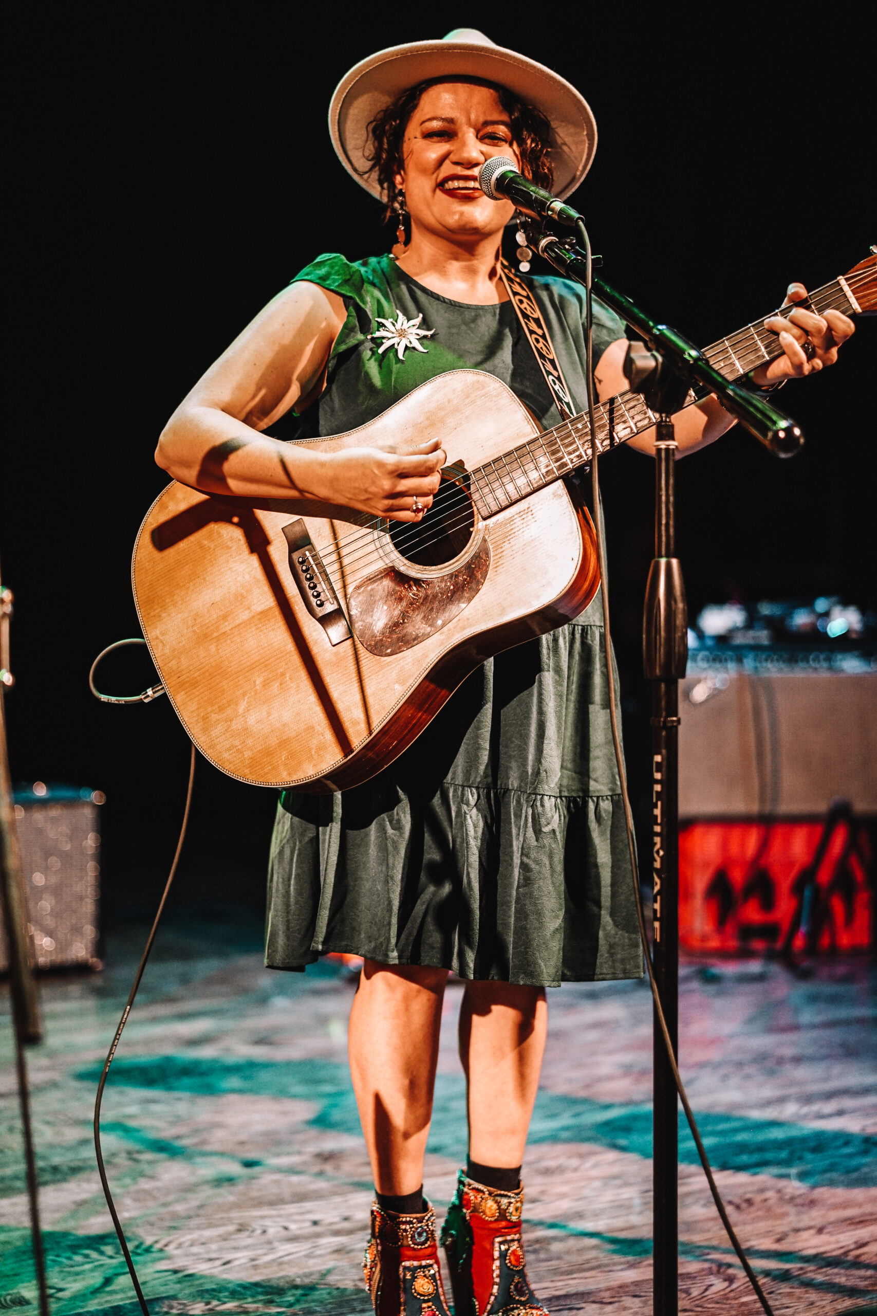 Elexa Dawson with guitar, at microphone.